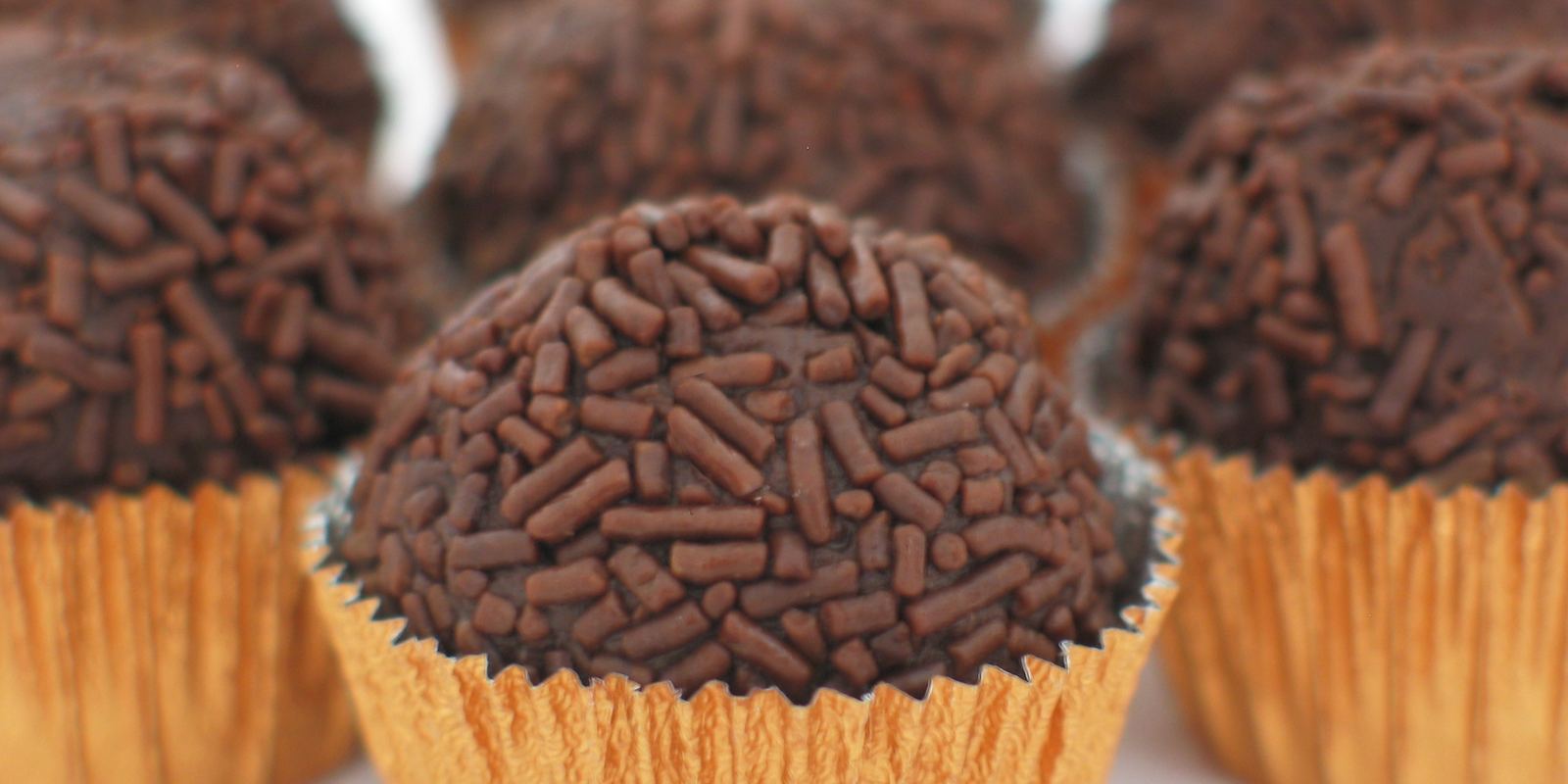 Round brigadeiros covered in chocolate sprinkles in paper cases