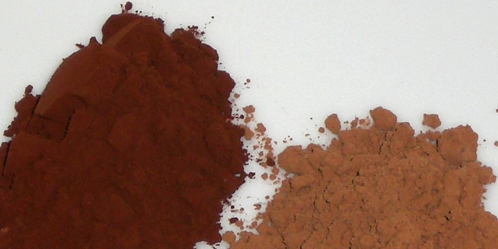 Two bowls of cocoa powder, one light brown natural and one darker Dutch-process