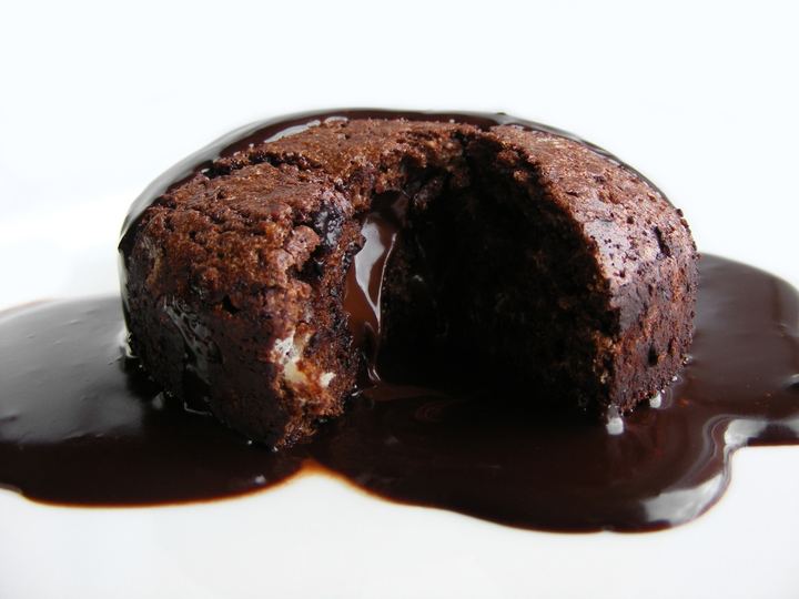 A small chocolate fondant cake with a runny centre on a plate