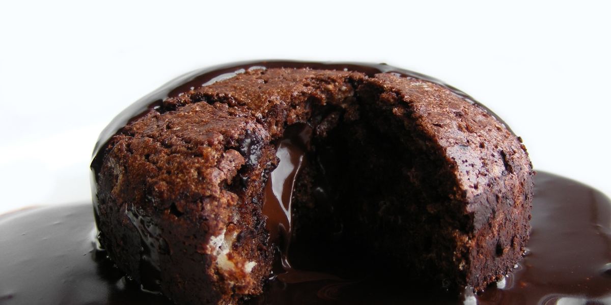A small chocolate fondant cake with a runny centre on a plate